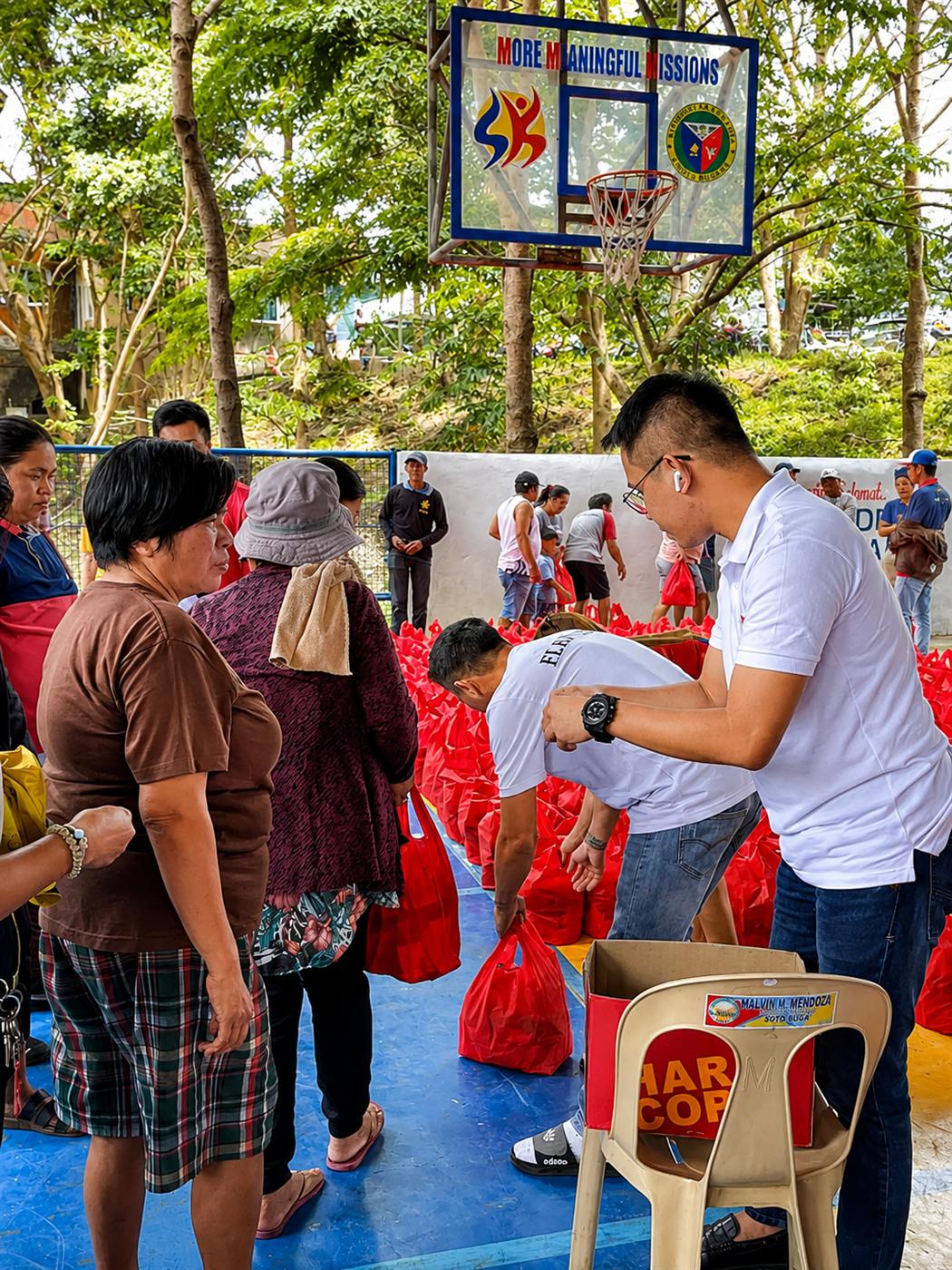 Flex team members helping distribute food packs at a community relief drive