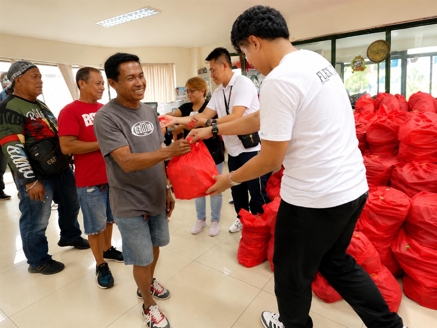 Food packs being passed hand to hand during a distribution event