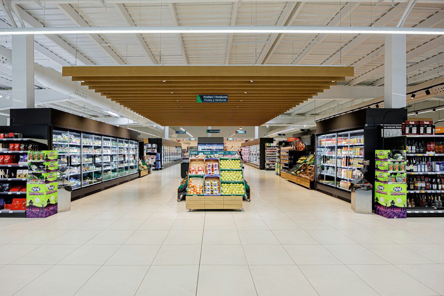 A brightly lit supermarket aisle stocked with general merchandise